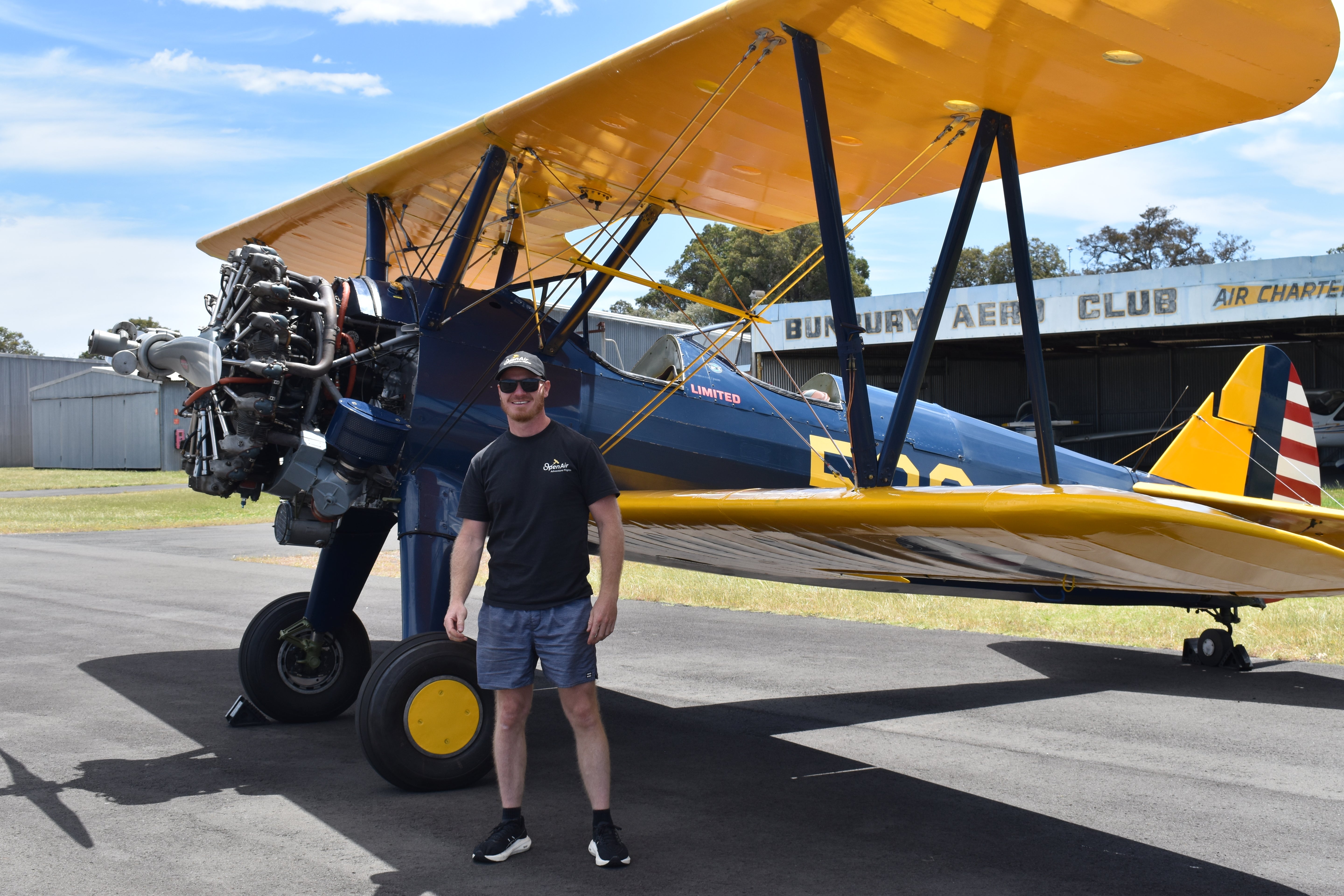 Johan Strydom standing in front of a vintage biplane Boeing Stearman at Bunbury airfield.