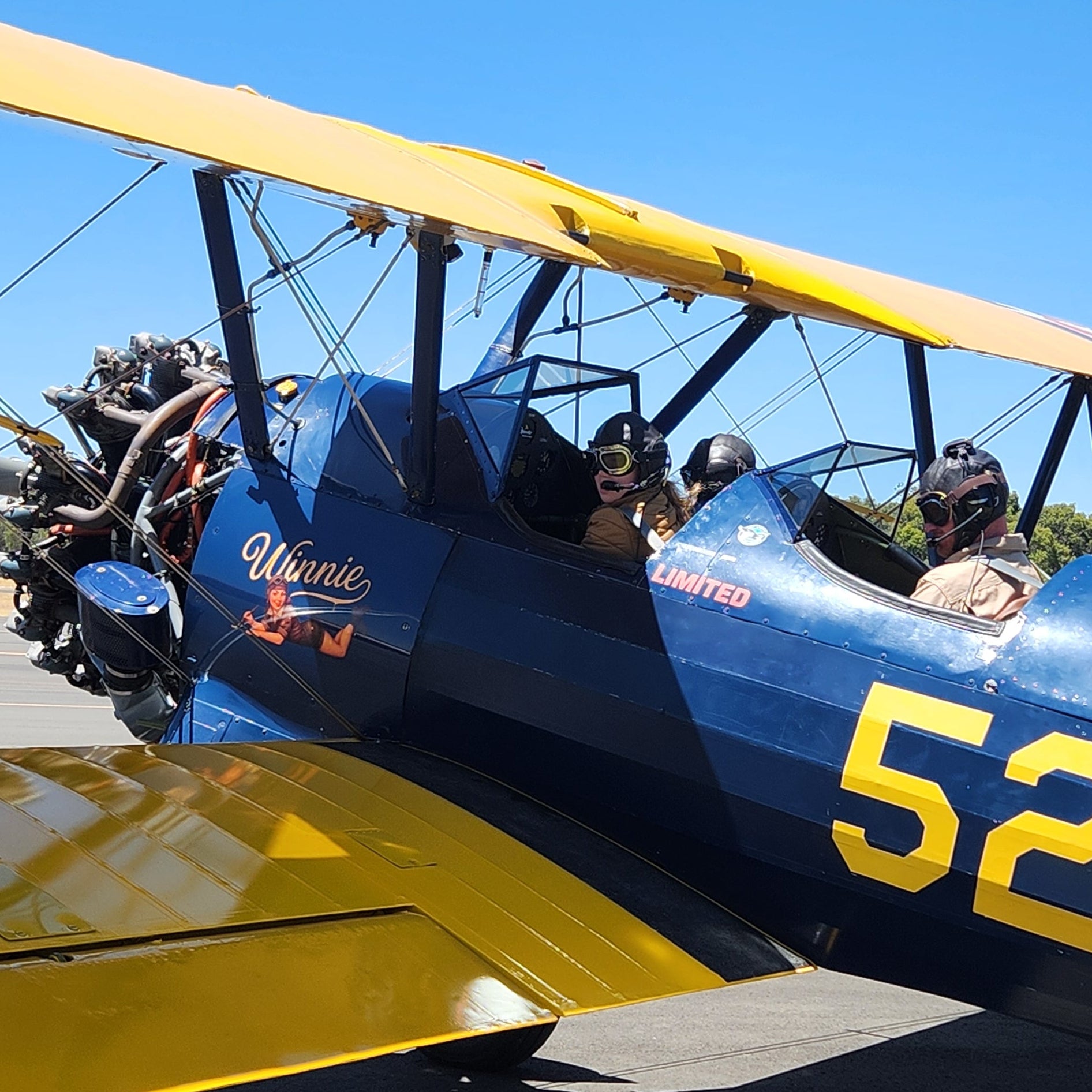 Johan preparing Boeing Stearman for takeoff with two children during an open cockpit flight in Bunbury